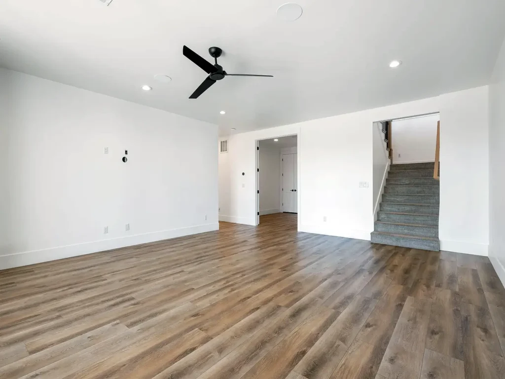 Finished basement with LVP flooring and ceiling fan