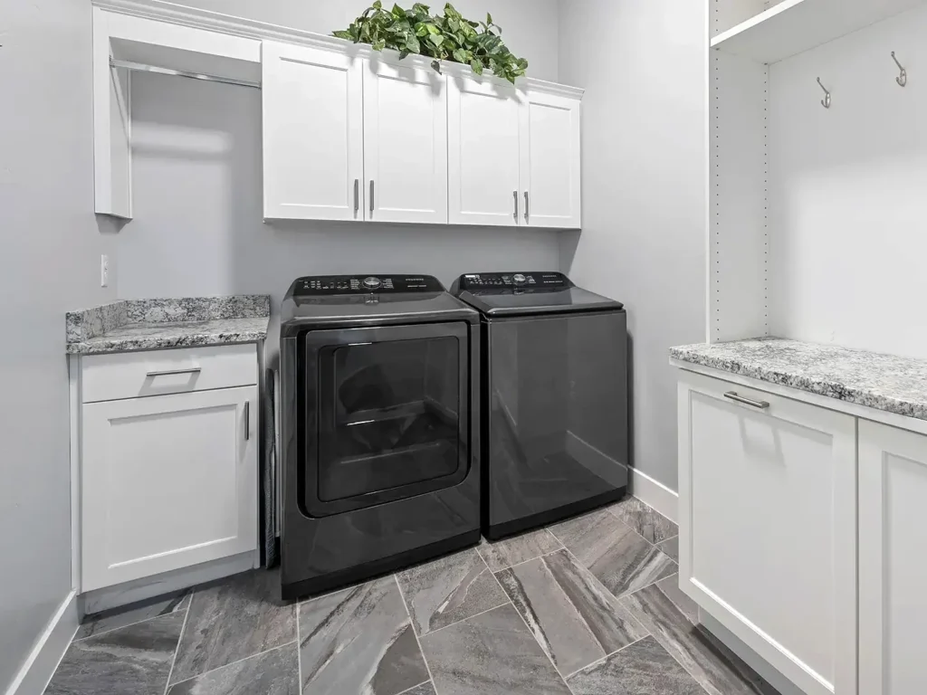 Finished basement laundry room in Utah with washer, dryer, built-in cabinets, and countertop workspace