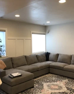 Utah Basement Finishing- a large living room with a sectional sofa and some custom trim on the walls