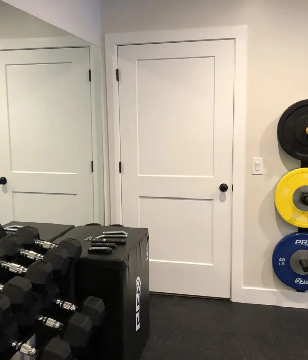 Basement Finishing Utah- basement home gym with colorful weights and a mirror