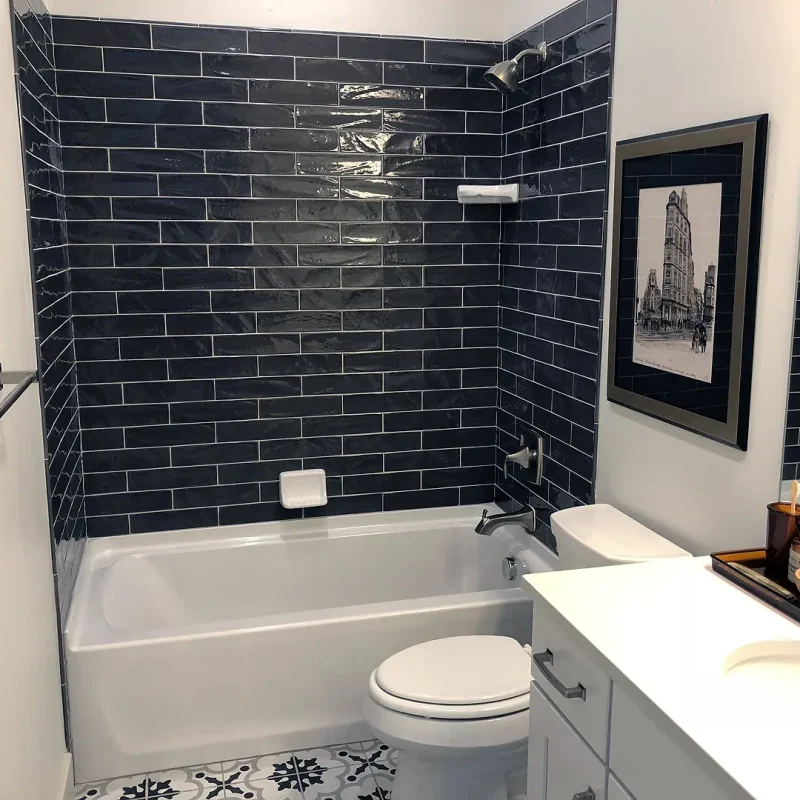 finished basement bathroom with dark tile shower and tub