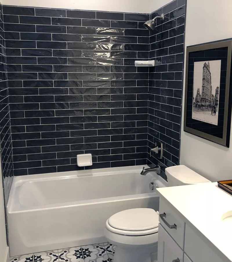 finished basement bathroom with dark tile shower and tub
