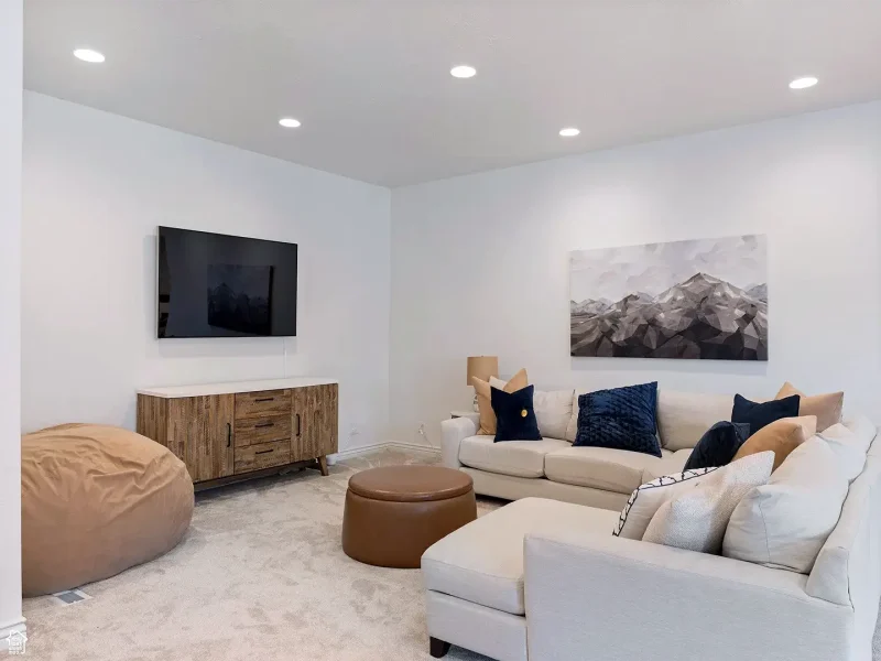Finished basement living room with recessed lighting, neutral finishes, and comfortable seating