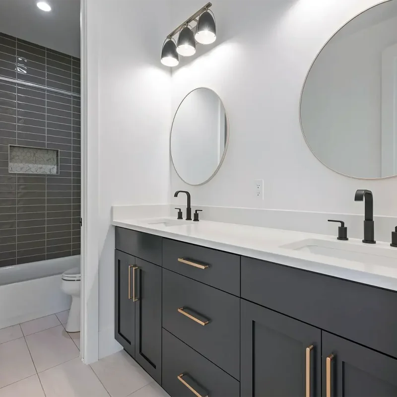 Basement Finishing Utah- a basement bathroom remodel with grey cabinets and custom mirrors