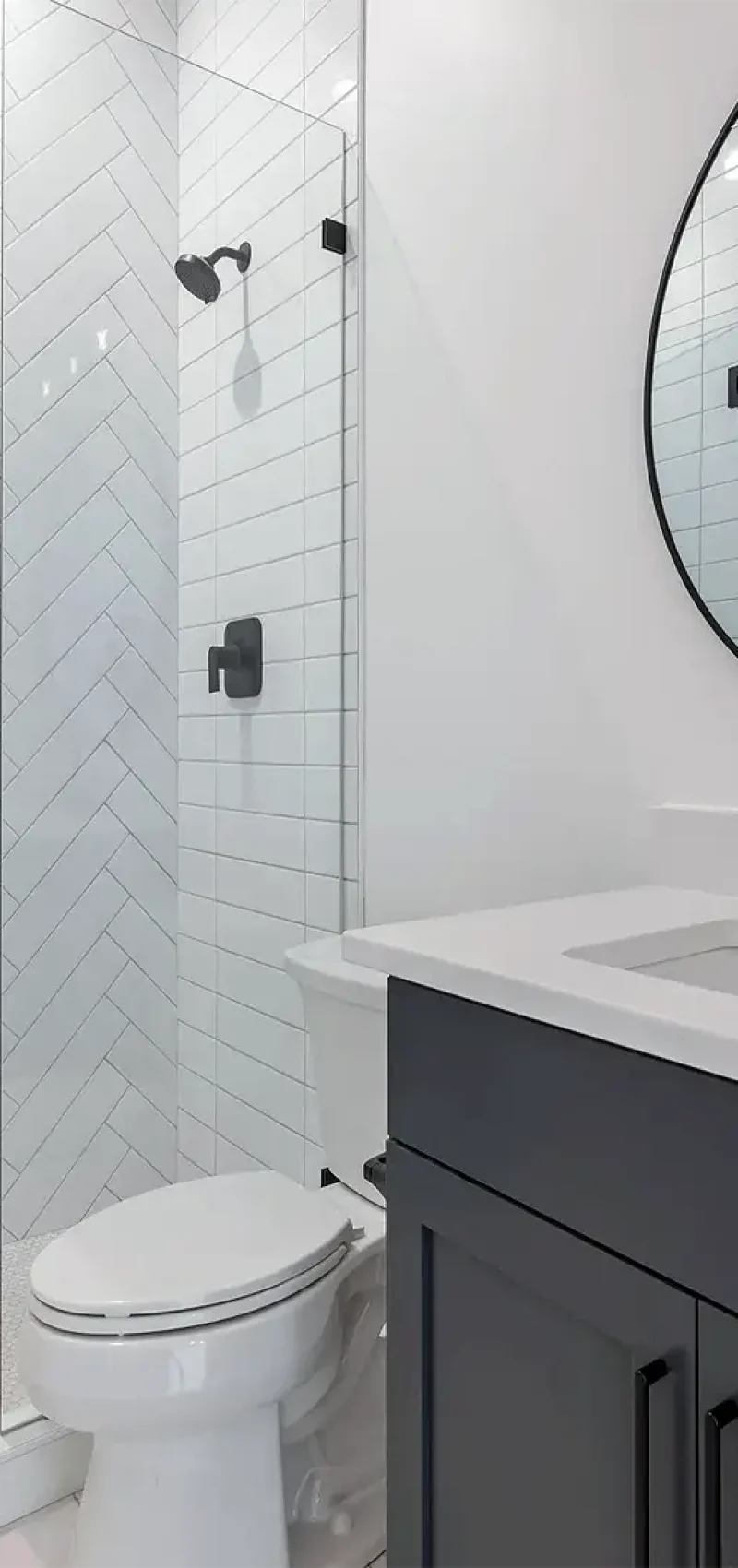 finished basement bathroom with herringbone tile shower and vanity