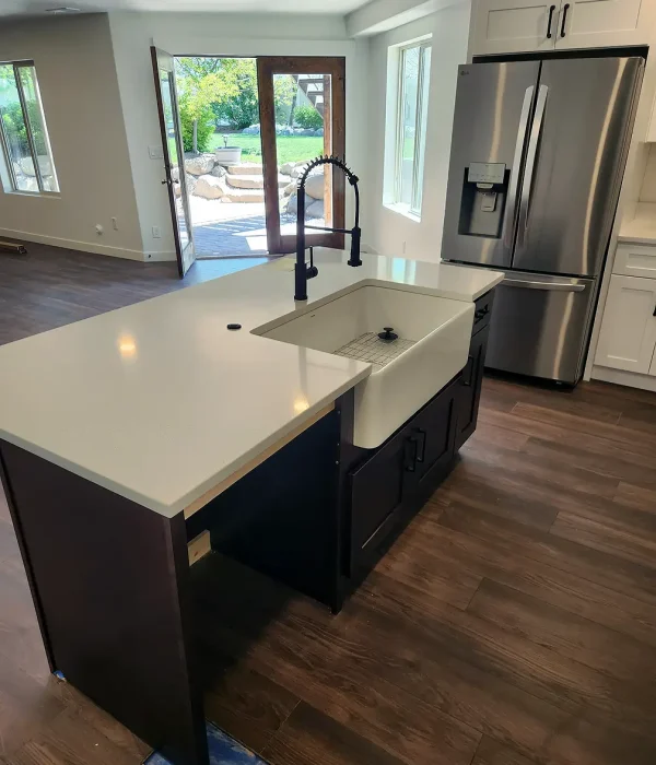Basement Finishing Utah- a basement kitchen with a walk-out entrance and an island with a garden sink