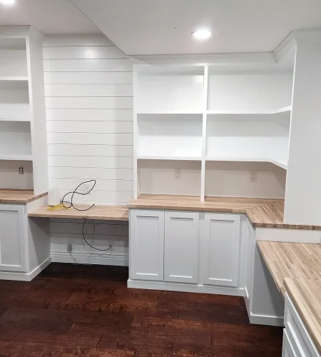 custom basement home office with built in cabinets and desk workspace